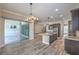 Open-concept kitchen with granite counters, stainless appliances, and wood-look tile flooring at 10149 Terrastone Dr, Las Vegas, NV 89148