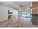 Open-concept living room with hardwood floors, a modern fireplace and an adjacent kitchen at 10149 Terrastone Dr, Las Vegas, NV 89148