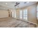 Spacious living room with wood-look tile flooring, plantation shutters, and designer lighting at 10149 Terrastone Dr, Las Vegas, NV 89148