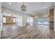 Bright living room featuring hardwood floors, a stylish light fixture and sliding glass doors to the backyard at 10149 Terrastone Dr, Las Vegas, NV 89148