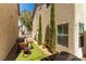 Backyard with artificial grass, grill, patio furniture, and narrow trees at 10254 Martinsburg Ct, Las Vegas, NV 89183