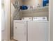 Functional laundry room with white washer, dryer and storage shelves at 10254 Martinsburg Ct, Las Vegas, NV 89183