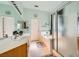 Bright bathroom featuring double sinks, a soaking tub with tile surround, and glass-enclosed shower at 10310 Songsparrow Ct, Las Vegas, NV 89135