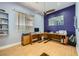Spacious office featuring a large desk, ceiling fan, wood floors, and ample natural light at 10310 Songsparrow Ct, Las Vegas, NV 89135