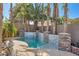 Inviting pool area featuring stone accents and lush landscaping for a private retreat at 10310 Songsparrow Ct, Las Vegas, NV 89135