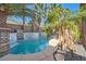 Picturesque pool with a waterfall feature, surrounded by palm trees and manicured landscaping at 10310 Songsparrow Ct, Las Vegas, NV 89135