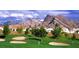 Scenic golf course view with lush green fairways, sand traps, and mountain views in the background at 10720 Sky Meadows Ave, Las Vegas, NV 89134
