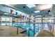 Bright indoor pool with large windows, clear blue water, and colorful flags at 10720 Sky Meadows Ave, Las Vegas, NV 89134