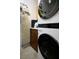 Laundry room featuring stacked washer and dryer, storage cabinets, and an ironing board at 10720 Sky Meadows Ave, Las Vegas, NV 89134