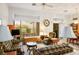 Spacious living room featuring large windows, traditional furnishings, and an open view of the adjacent dining room at 10720 Sky Meadows Ave, Las Vegas, NV 89134