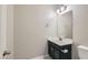 Stylish half bathroom featuring a sleek vanity with dark cabinetry and modern fixtures at 10744 Yarmouth Bay Ct, Las Vegas, NV 89179