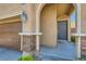 Close-up on the home's entryway with a gray front door, stylish sconces, and stacked stone details at 10744 Yarmouth Bay Ct, Las Vegas, NV 89179