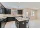 Modern kitchen featuring granite countertops, black cabinets, and an island with barstool seating at 10744 Yarmouth Bay Ct, Las Vegas, NV 89179