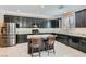 Modern kitchen featuring stainless appliances, granite countertops, black cabinetry, and an island with seating at 10744 Yarmouth Bay Ct, Las Vegas, NV 89179