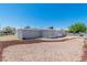 View of the home showcasing its light gray exterior, simple landscaping, and spacious yard at 1121 W Monroe Ave, Las Vegas, NV 89106