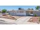 Charming single-story home with light gray exterior, stone accents, secure windows, and a carport at 1121 W Monroe Ave, Las Vegas, NV 89106