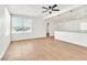 Open-concept living room with light wood flooring and white walls, flowing seamlessly into the modern kitchen with a breakfast bar at 1121 W Monroe Ave, Las Vegas, NV 89106