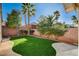 Private backyard features manicured lawn, mature trees, brick fence, and concrete patios at 1506 Camino Summit Ave, Henderson, NV 89012