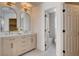 Elegant bathroom featuring double vanity with arched mirrors and a view into the separate toilet and shower room at 1506 Camino Summit Ave, Henderson, NV 89012