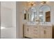 Elegant bathroom featuring a double vanity with decorative mirrors and lighting fixtures at 1506 Camino Summit Ave, Henderson, NV 89012