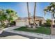 Charming single-story home featuring manicured lawn, palm trees, a paved driveway, and a two-car garage at 1506 Camino Summit Ave, Henderson, NV 89012
