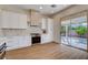 Modern kitchen featuring stainless steel appliances, white cabinetry, tile backsplash, and sliding glass doors to the patio at 1506 Camino Summit Ave, Henderson, NV 89012