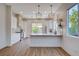 Bright kitchen features modern appliances, pendant lighting, white cabinets, and a counter with a bar overhang at 1506 Camino Summit Ave, Henderson, NV 89012