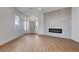 Bright living space with a modern fireplace, light wood floors, and large windows illuminating the room at 1506 Camino Summit Ave, Henderson, NV 89012