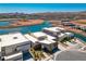Aerial view of a modern home nestled on a waterfront property with lake and mountain views at 1596 Pleasant Bay Ct, Henderson, NV 89011