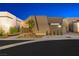Stunning modern home with a unique architectural design and desert landscaping at dusk at 1596 Pleasant Bay Ct, Henderson, NV 89011