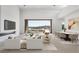 Bright living room featuring modern furnishings, a fireplace, and a stunning lake view through large sliding glass doors at 1596 Pleasant Bay Ct, Henderson, NV 89011