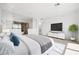 Bright main bedroom featuring a decorative tree, TV, white dresser and ensuite bath with glass enclosure at 1596 Pleasant Bay Ct, Henderson, NV 89011
