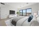Main bedroom with a large window, white dresser, TV, ensuite bath and bright view of the lake at 1596 Pleasant Bay Ct, Henderson, NV 89011