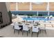 Charming poolside dining area with a table setting, lounge chairs, and a view of mountains at 1596 Pleasant Bay Ct, Henderson, NV 89011