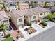 Townhouse aerial view featuring two garages, desert landscaping, and neighborhood street at 1604 Patrick Thomas Ct, North Las Vegas, NV 89086