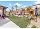 Expansive backyard with lush artificial turf, mature trees, play set, and outdoor seating at 1604 Patrick Thomas Ct, North Las Vegas, NV 89086