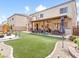 Large backyard with artificial turf, patio area, and a play set, perfect for outdoor activities at 1604 Patrick Thomas Ct, North Las Vegas, NV 89086