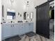 Elegant bathroom featuring double sinks, modern lighting fixtures, and a sliding barn door at 1604 Patrick Thomas Ct, North Las Vegas, NV 89086