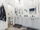 Bright bathroom featuring dual vanities with gray cabinets, mirrors, and modern lighting fixtures at 1604 Patrick Thomas Ct, North Las Vegas, NV 89086