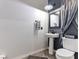 Stylish half-bathroom with a pedestal sink, modern fixtures, and elegant decor elements at 1604 Patrick Thomas Ct, North Las Vegas, NV 89086
