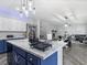 Bright kitchen with an island featuring a white marble countertop and blue cabinets at 1604 Patrick Thomas Ct, North Las Vegas, NV 89086