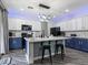 Modern kitchen with blue and white cabinets, stylish lighting fixture, and marble countertops at 1604 Patrick Thomas Ct, North Las Vegas, NV 89086