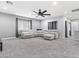 Spacious living room with a gray sectional couch, ceiling fan, and neutral decor throughout at 1604 Patrick Thomas Ct, North Las Vegas, NV 89086