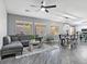 Open-concept living area with a gray sofa, dining table, and modern kitchen in view at 1604 Patrick Thomas Ct, North Las Vegas, NV 89086