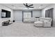 Modern living room with a plush gray sectional, a large TV, and a ceiling fan at 1604 Patrick Thomas Ct, North Las Vegas, NV 89086