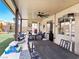 Covered patio with a ceiling fan, ample seating, and views of the backyard play area at 1604 Patrick Thomas Ct, North Las Vegas, NV 89086