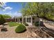 Landscaped backyard featuring synthetic grass, desert landscaping, and a covered patio at 2029 Poppywood Ave, Henderson, NV 89012