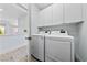 Laundry room with front load washer and dryer and white cabinets at 2029 Poppywood Ave, Henderson, NV 89012