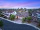 Beautiful neighborhood with manicured lawns, lush green trees, and colorful sunset sky at 2116 Canvas Edge Dr, Henderson, NV 89044