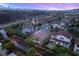 Scenic community featuring varied home styles, lush trees, and mountain views under a vibrant twilight sky at 2116 Canvas Edge Dr, Henderson, NV 89044